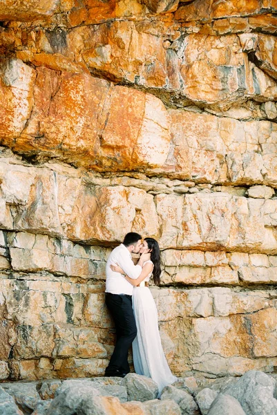 Groom Kisses Bride Holding Her Face His Hands Huge Stone — Stockfoto