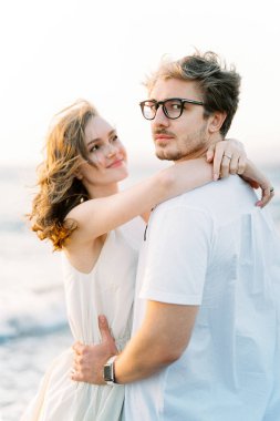 Smiling woman hugging neck of man with glasses. High quality photo