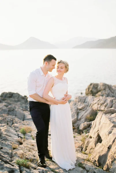 Groom Hugs Bride Standing Rocks Sea High Quality Photo — Stok Foto