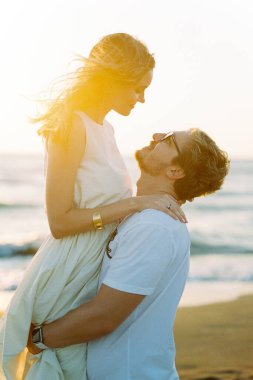 Smiling man raised woman in his arms. High quality photo