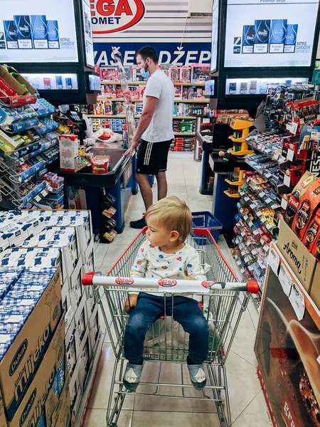Small Child Sits Trolley Supermarket Shelves Groceries High Quality Photo — Stock Fotó