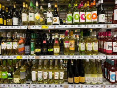 Multi-colored bottles with wine on the shelves in the supermarket. High quality photo
