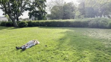 Mom and little girl lie on a green lawn. High quality 4k footage