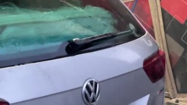 Service worker washing a car with a hose at a car wash. High quality FullHD footage