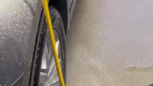 Car Service Worker Washes Wheels Car Hose Pressurized Water High — Stockvideo