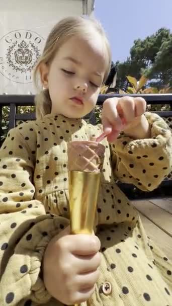 Little Girl Eating Ice Cream Waffle Cone Spoon Gold Foil — Video