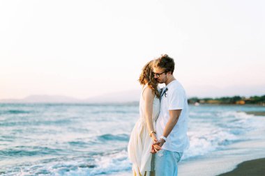 Man and woman hugging holding hands on the beach. High quality photo
