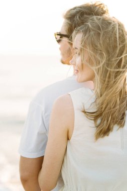 Woman hugging man from behind. Back view. High quality photo