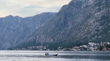 Bir adam sahil kasabasının yakınındaki bir teknede yüzüyor. Yüksek kalite 4k görüntü