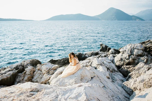 Gelin Dağların Arka Planında Kayalık Bir Deniz Kıyısında Oturur Kafasını — Stok fotoğraf