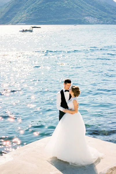 新郎は山の背景に桟橋に花嫁を抱擁 高品質の写真 — ストック写真