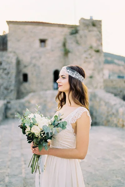 Nevěsta Kyticí Květin Rukou Pozadí Staré Kamenné Pevnosti Kvalitní Fotografie — Stock fotografie