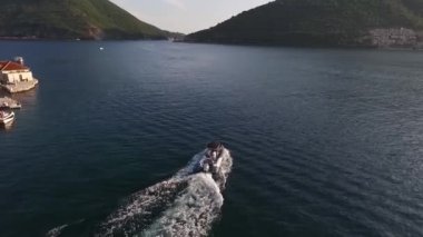 Motorlu tekne Gospa od Skrpjela adasından geçiyor. Karadağ. Yüksek kaliteli FullHD görüntüler