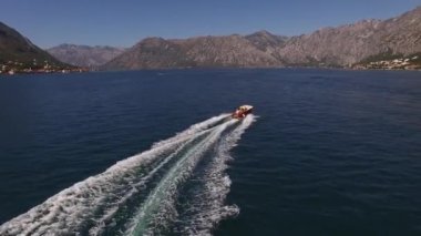 Motorlu yat, dağların eteğinde körfezde yüzüyor. Yüksek kalite 4k görüntü