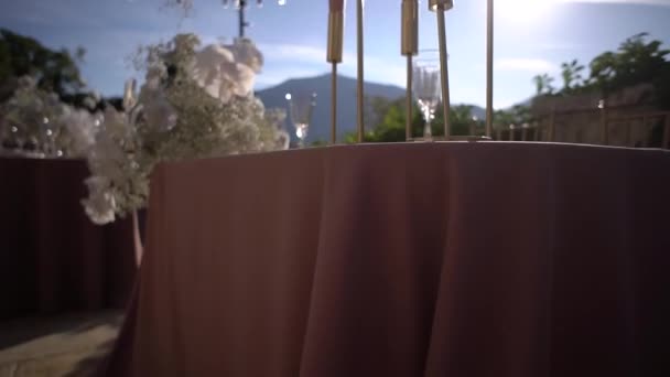 山を背景に海沿いのテラスのテーブルの上にキャンドルスティックでキャンドル 高品質のフルHd映像 — ストック動画