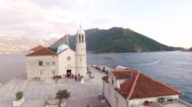 Gelin ve konuklar Kayalıklar Leydisi Kilisesi 'nin önünde dururlar. Kotor Körfezi. Yüksek kaliteli FullHD görüntüler