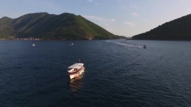 Denizde yüzen teknelerin uzaktan kumandalı görüntüsü yeşil dağların arka planında. Yüksek kaliteli FullHD görüntüler