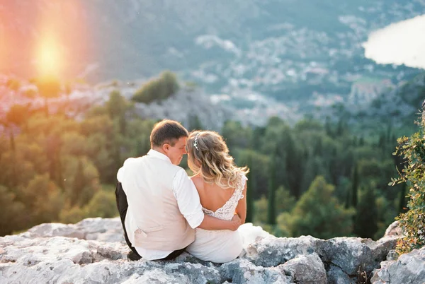 新娘和新郎拥抱着坐在山顶上 高质量的照片 — 图库照片