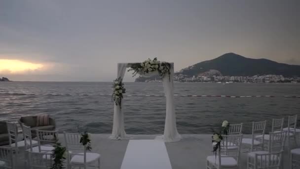 Σειρές Από Λευκές Καρέκλες Στέκονται Μπροστά Από Μια Γαμήλια Αψίδα — Αρχείο Βίντεο