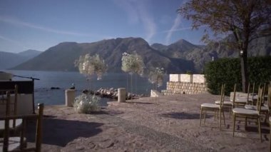 Beyaz çiçek buketleri rıhtımdaki sıra sıra sandalyelerin önünde duruyor. Yüksek kaliteli FullHD görüntüler