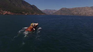 Kumsalı geçtikten sonra deniz boyunca birkaç yelkenli ile kahverengi küçük bir yat. Yüksek kalite 4k görüntü