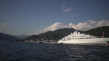 Denizdeki lüks beyaz yat, dağların arka planına karşı. Yüksek kaliteli FullHD görüntüler