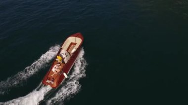 Denizde yüzen kahverengi bir teknede kucaklaşan çift. Yüksek kalite 4k görüntü