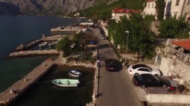 Araba dağların eteğindeki tatil köyü boyunca gidiyor. Yüksek kalite 4k görüntü