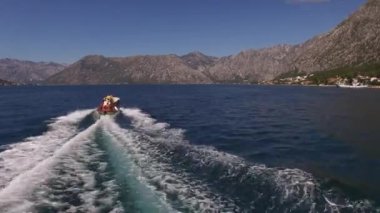 Motorlu yat, bir dağ sırasının arka planına karşı denizde yelken açar. Yüksek kalite 4k görüntü