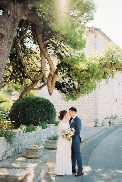 Menyasszony Vőlegény Egy Alatt Állnak Utcán Szemben Egy Kőház Hátterével — Stock Fotó