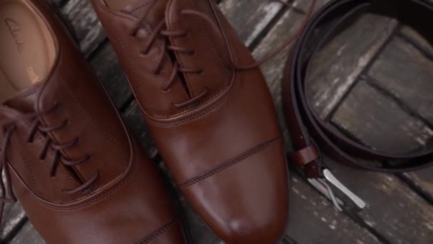 革の男性の靴は テーブルの上に折り畳まれたベルト 香水や時計の横に立つ 高品質のフルHd映像 — ストック動画