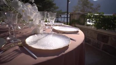 Tabaklar ve bardaklar masanın üzerinde bir buket çiçeğin yanında. Yüksek kaliteli FullHD görüntüler