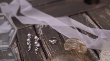 Alyanslar bir kutuda parfüm, bir buket çiçek ve dantel jartiyerin yanında duruyor. Yüksek kaliteli FullHD görüntüler