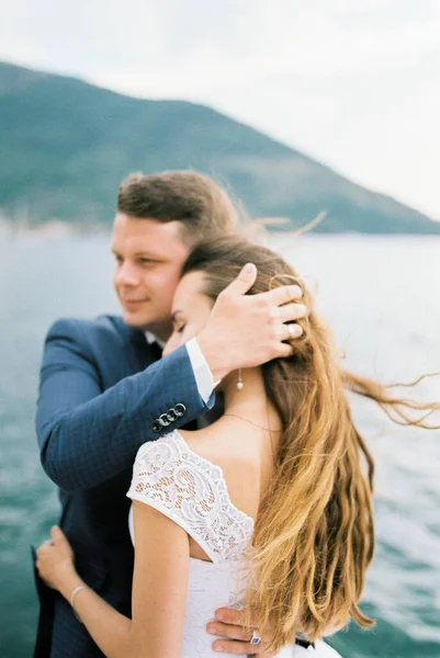 Novio Abraza Novia Cubriendo Cabeza Con Mano Del Viento Orilla — Foto de Stock