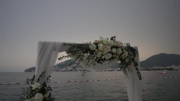 Bröllopsbåge Dekorerad Med Rosor Och Vitt Tyg Står Vid Havet — Stockvideo