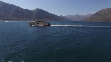 Beyaz yat, deniz kıyısında köpük izi bırakarak yüzüyor. Yüksek kalite 4k görüntü