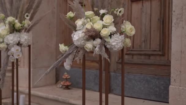 Μπουκέτα Λουλούδια Στις Κερκίδες Στέκονται Στο Κατώφλι Της Εκκλησίας Υψηλής — Αρχείο Βίντεο