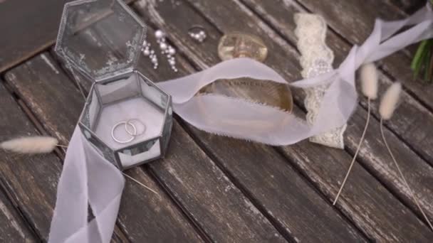 結婚指輪の箱は香水及び真珠の宝石類のボトルの隣の木製のテーブルに立つ 高品質のフルHd映像 — ストック動画