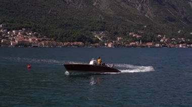 Bir adam ve kadın, sahil boyunca giden bir motorlu teknenin güvertesinde yatıyorlar. Yüksek kaliteli FullHD görüntüler