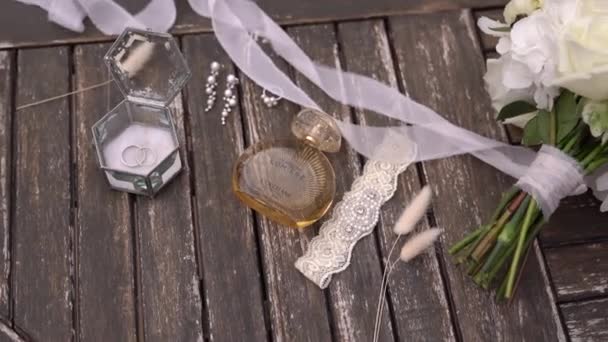Свадебные Кольца Кружевная Подвязка Украшения Духи Столе Надпись Terre Lumiere — стоковое видео