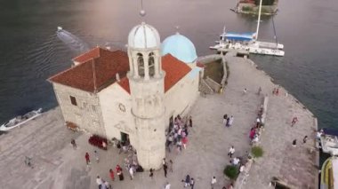Kayalıklar Kadını Kilisesi 'nin etrafında insanlar dolaşıyor. Karadağ. Yüksek kaliteli FullHD görüntüler