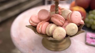 Masanın üzerinde çok renkli badem kurabiyeli tabak rafı duruyor. Yüksek kaliteli FullHD görüntüler