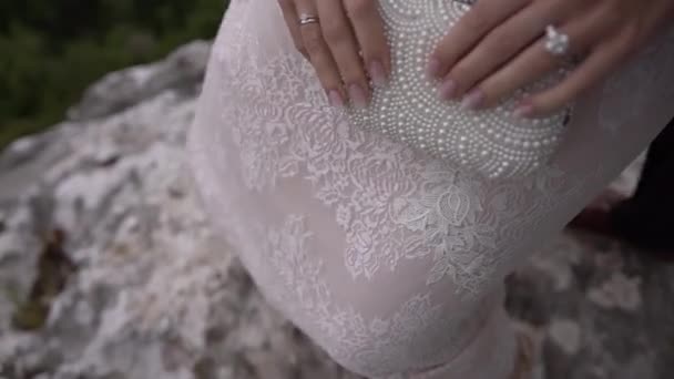 Noiva Fica Sobre Pedras Segurando Saco Embreagem Decorado Com Pérolas — Vídeo de Stock