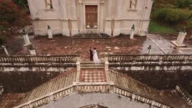 Gelin ve damat Meryem 'in Doğumu Kilisesi' nin arka planında sarılıyor. Prcanj. Yüksek kalite 4k görüntü