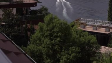 Denizde yelken açan bir motorlu tekneyle otelin terasından bir görüntü. Yüksek kaliteli FullHD görüntüler