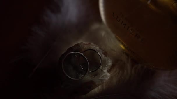 结婚戒指躺在一瓶女性香水旁边的一块扁平的石头上 Terre Lumiere Leau Loccitane 优质Fullhd影片 — 图库视频影像