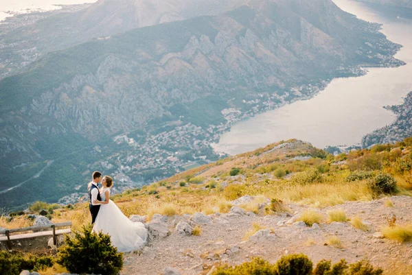 Groom Abraça Noiva Monte Lovcen Perto Banco Contra Pano Fundo — Fotografia de Stock