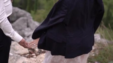 Damat elini rüzgarda tutarak ceketini gelinin üzerine attı. Yüksek kaliteli FullHD görüntüler