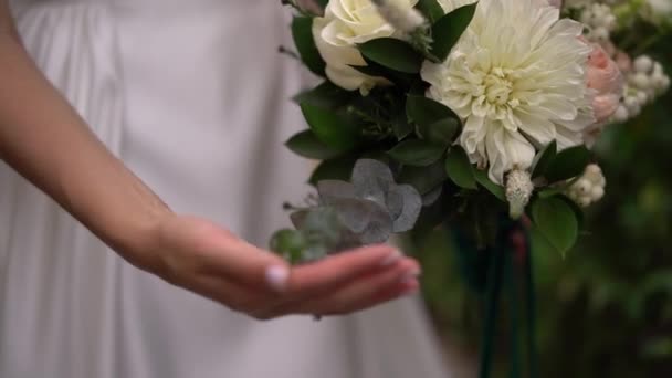 Νύφη Λευκό Φόρεμα Χαϊδεύει Ένα Μπουκέτο Λουλούδια Υψηλής Ποιότητας Υλικό — Αρχείο Βίντεο