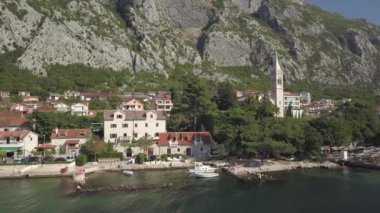 Evleri ve kilise kulesi olan Dobrota köyünün kıyısında. Karadağ. Yüksek kalite 4k görüntü